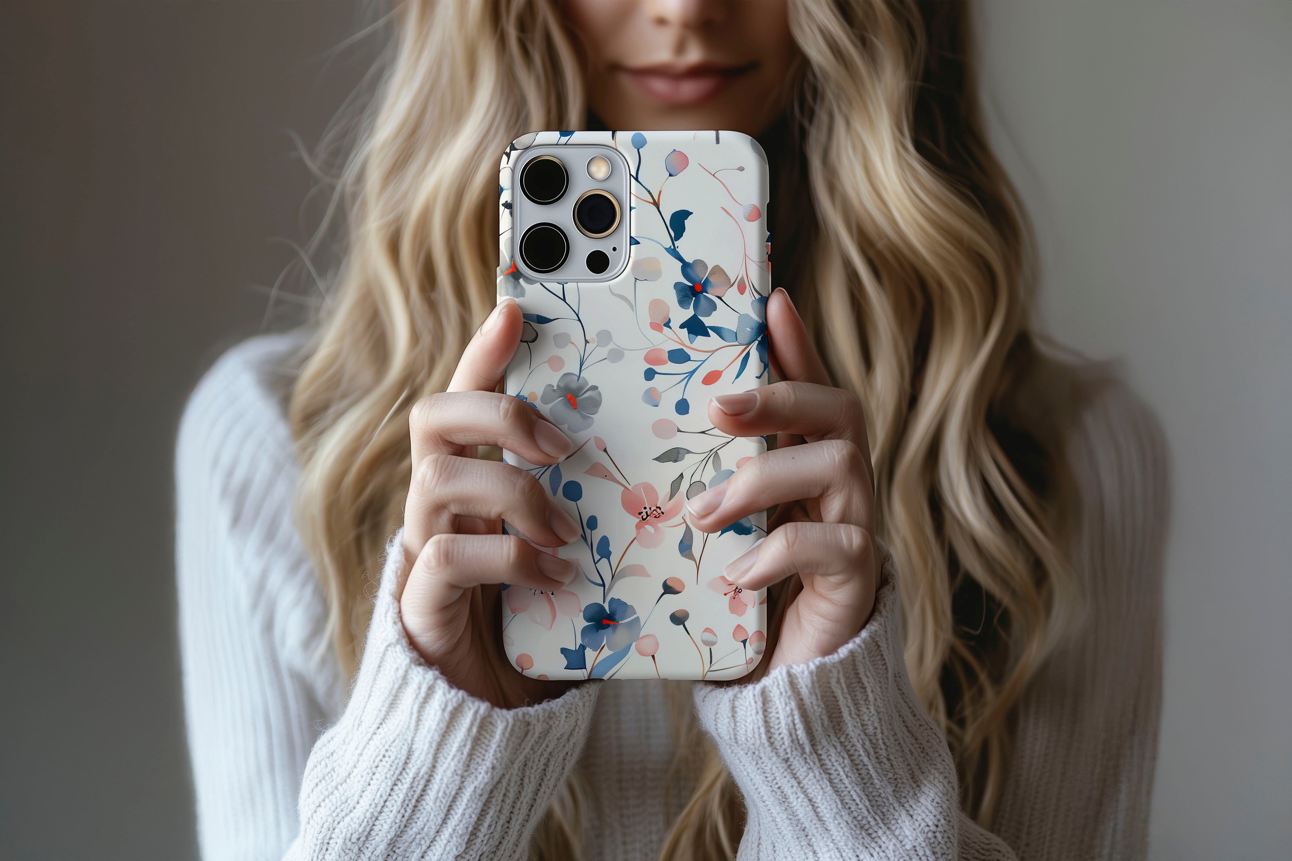 A cute girl holding a phone case featuring our Blue & Pink Floral design