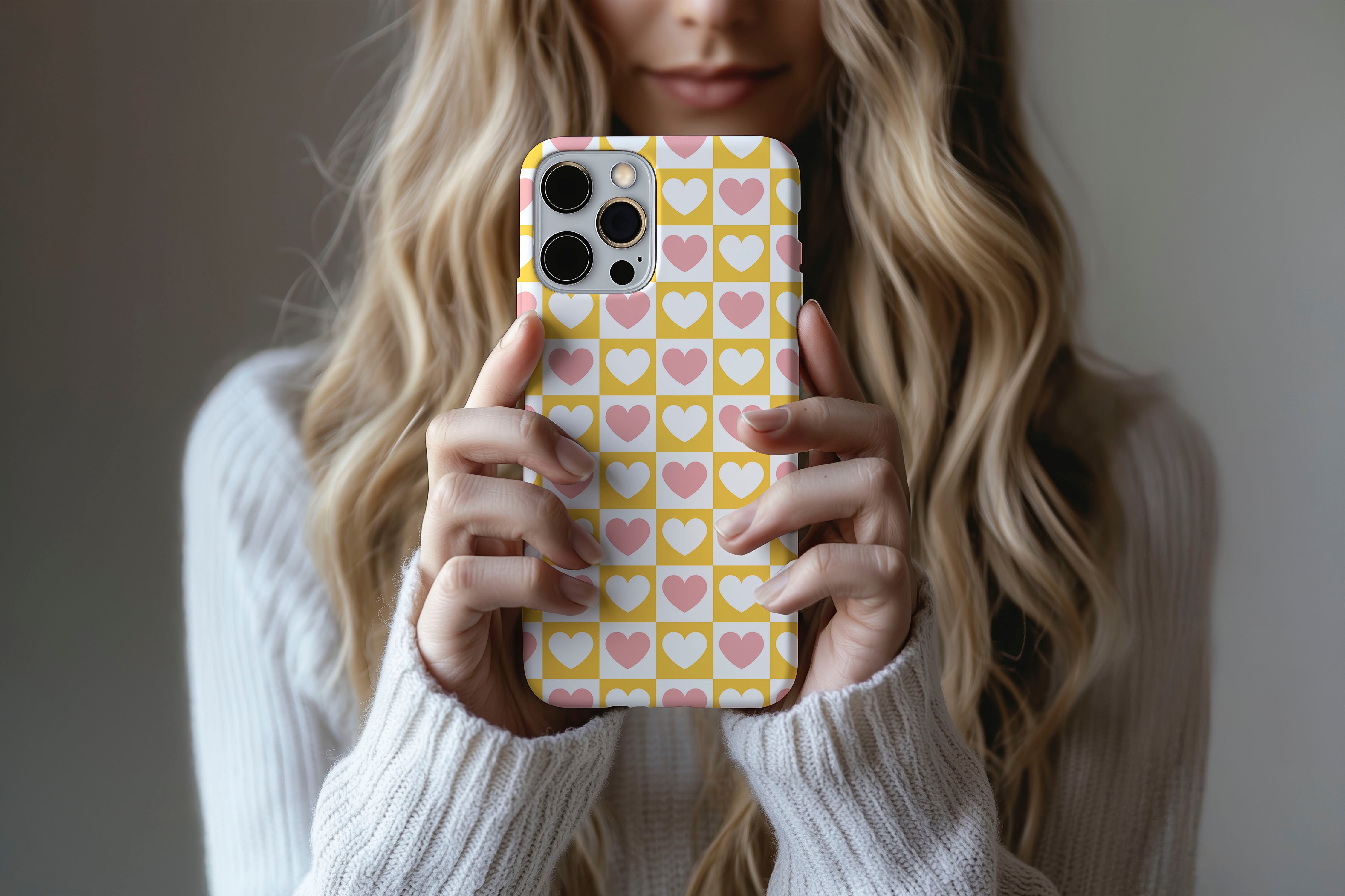 A cute girl holding a phone case featuring our Check Heart design