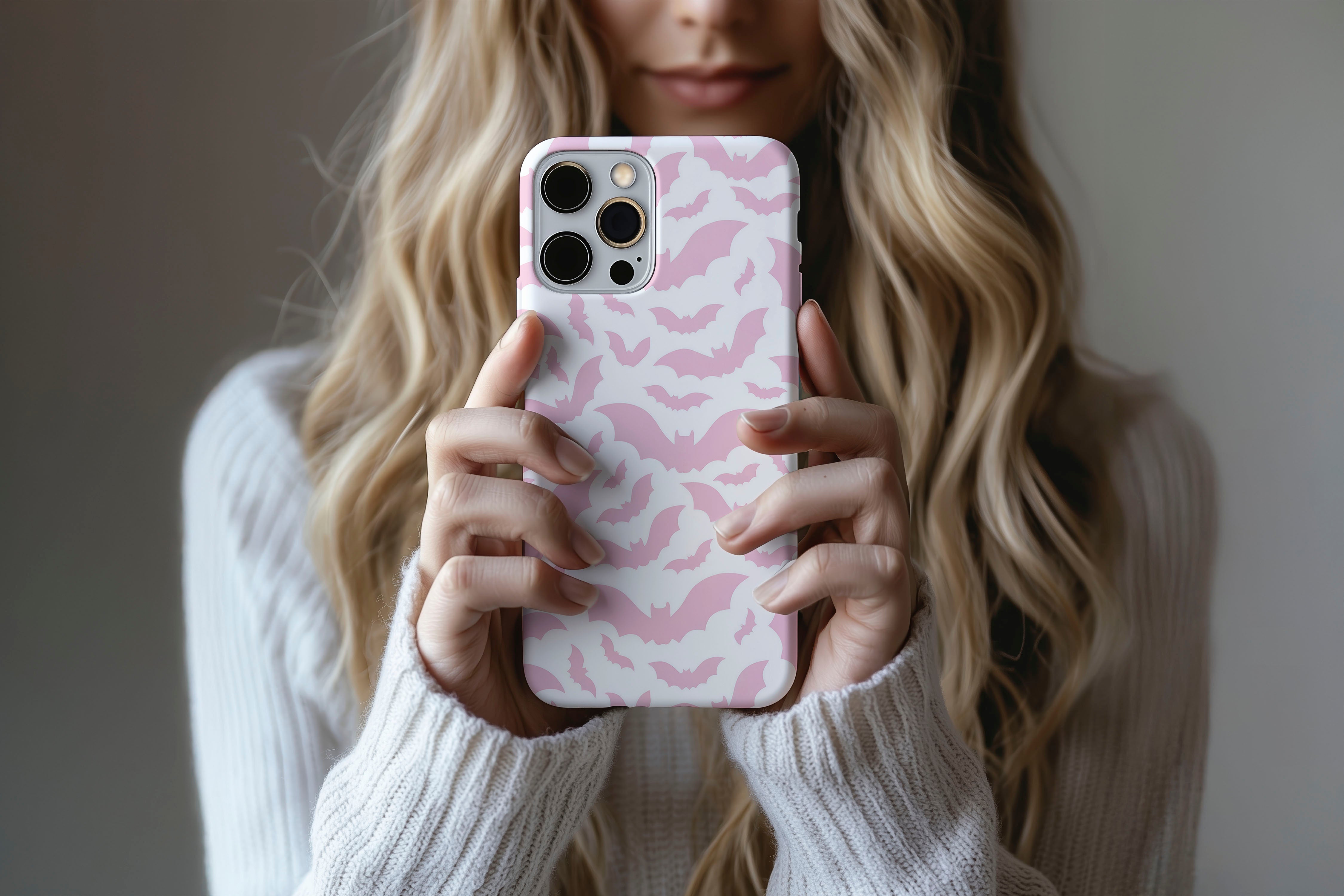 A cute girl holding a phone case featuring our Pink Bats design
