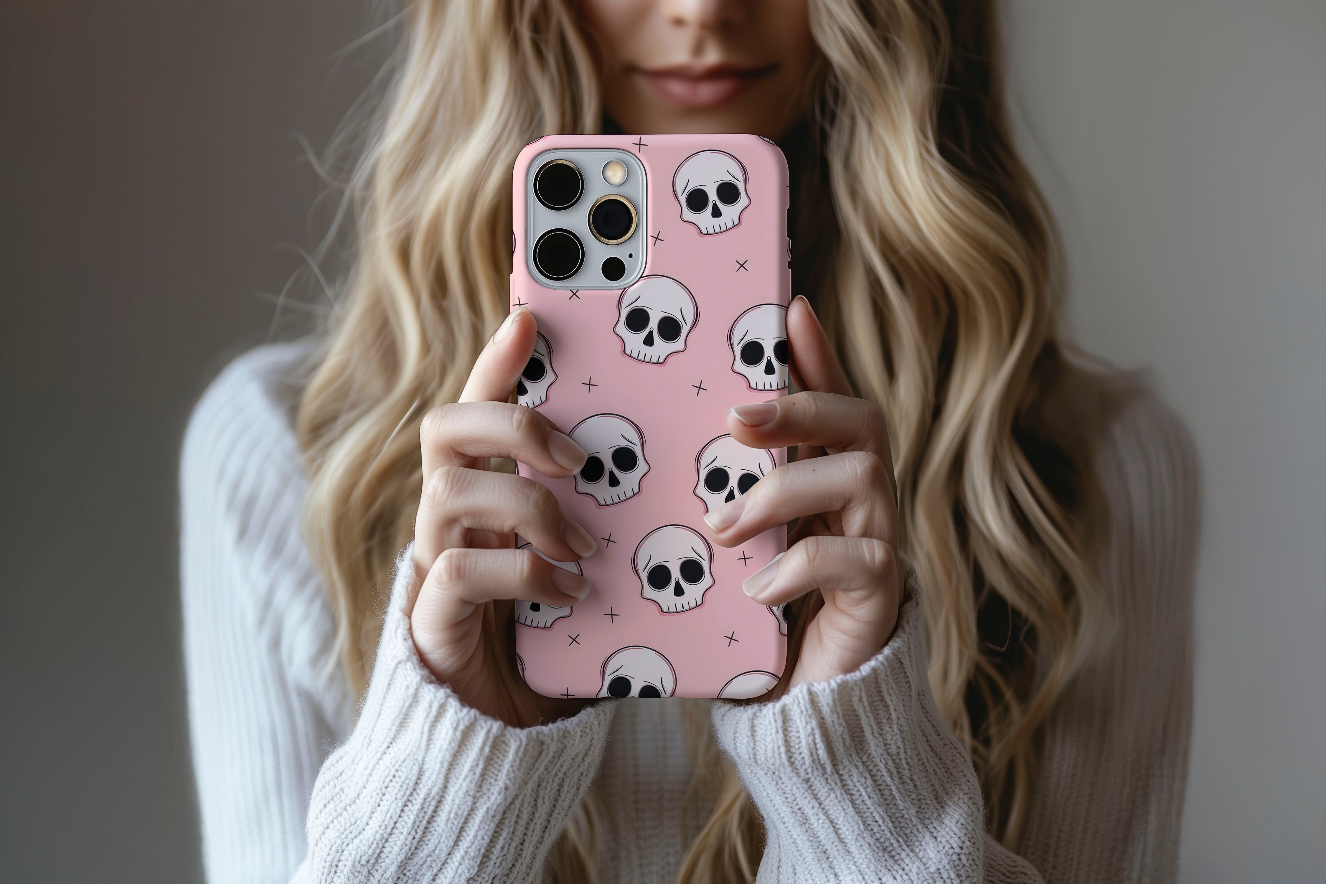 A cute girl holding a phone case featuring our Skulls design