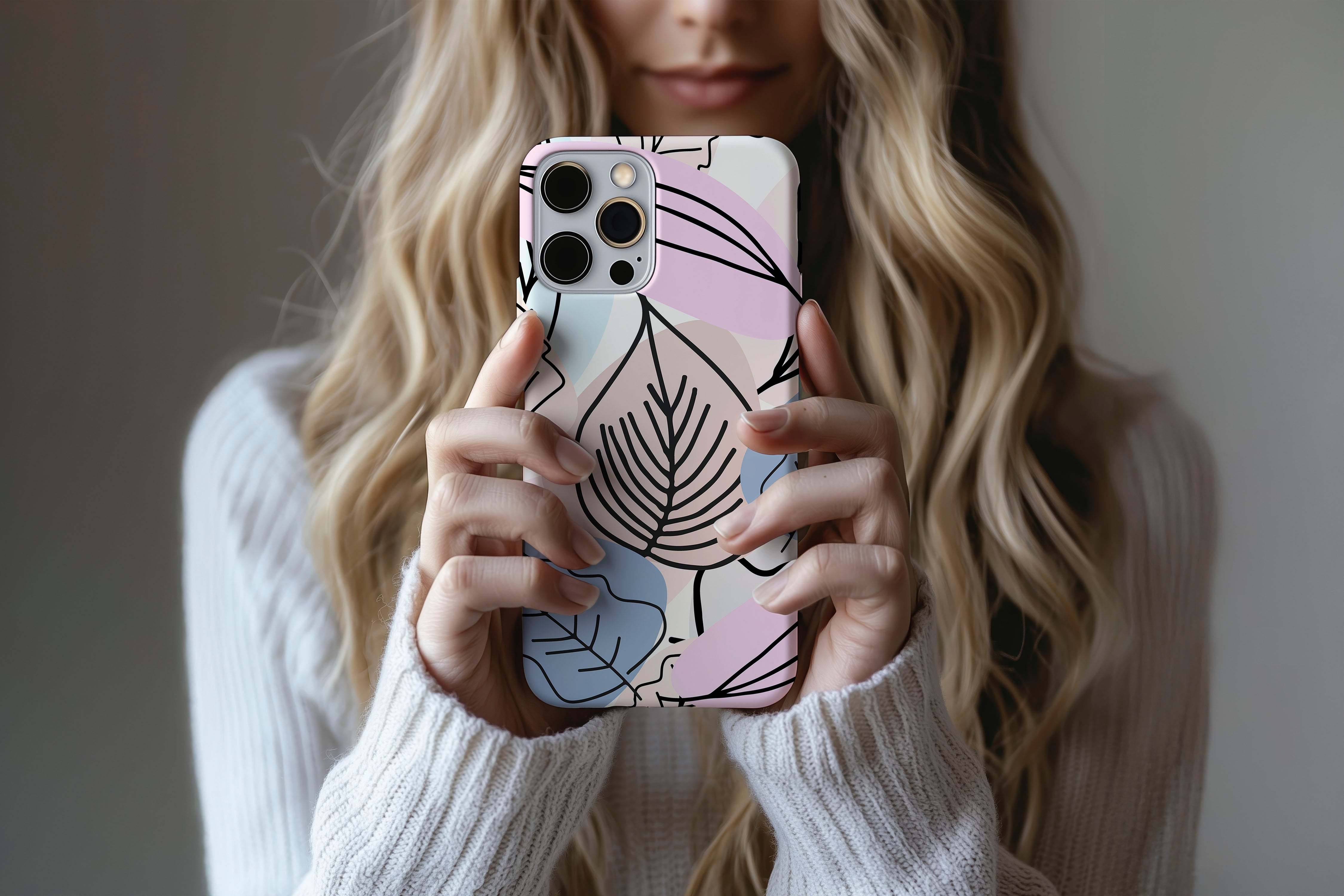 A cute girl holding a phone case featuring our Abstract Leaves design