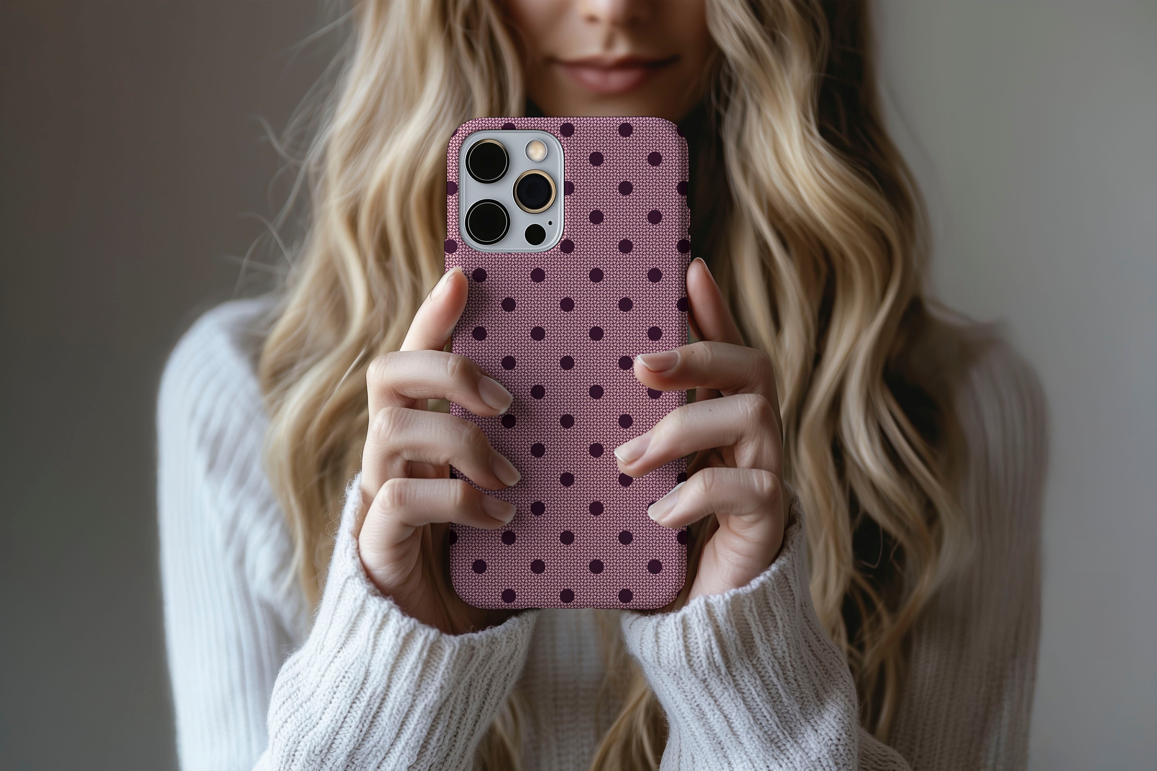 A cute girl holding a phone case featuring our Burgundy Spot design