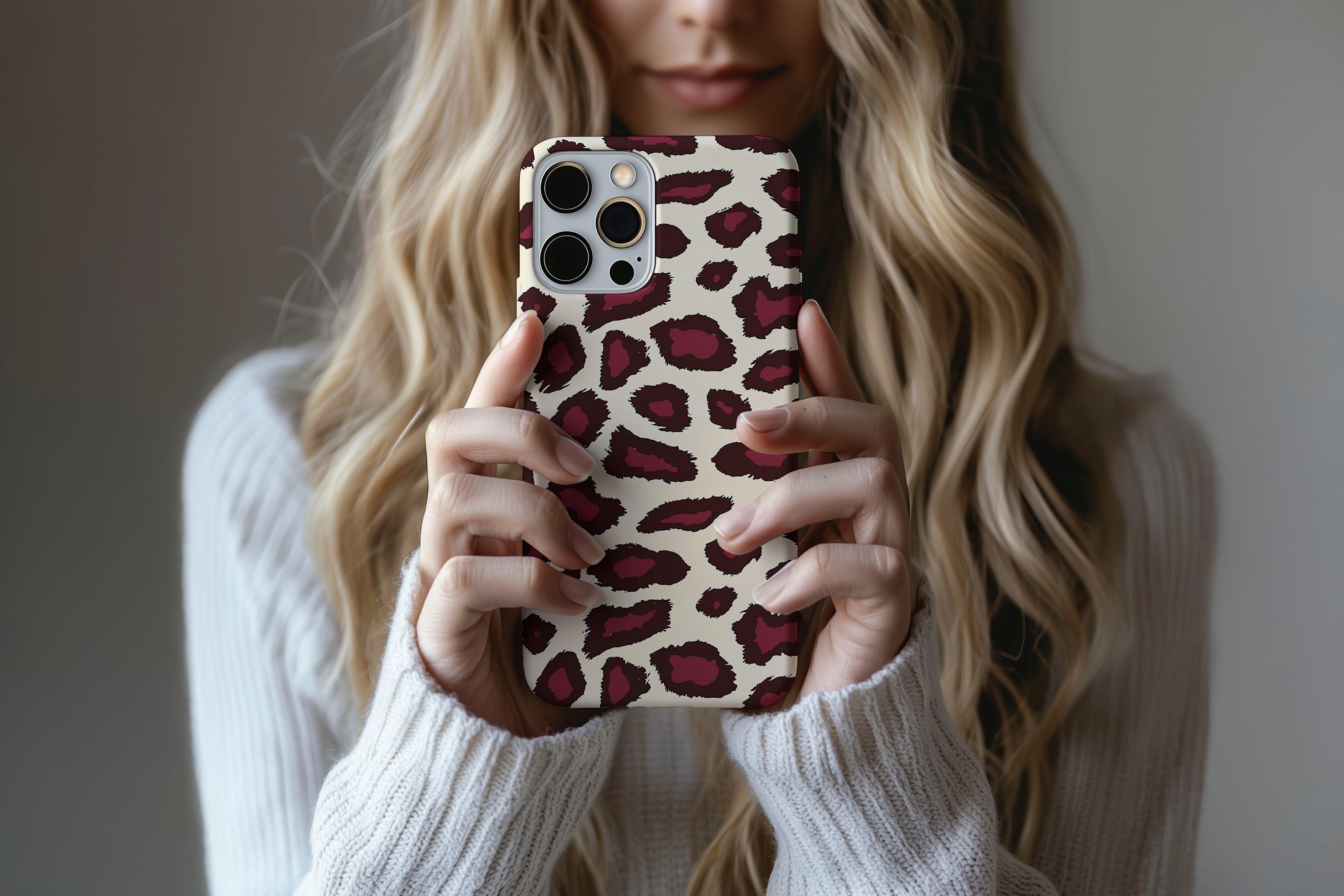 A cute girl holding a phone case featuring our Burgundy Leopard design