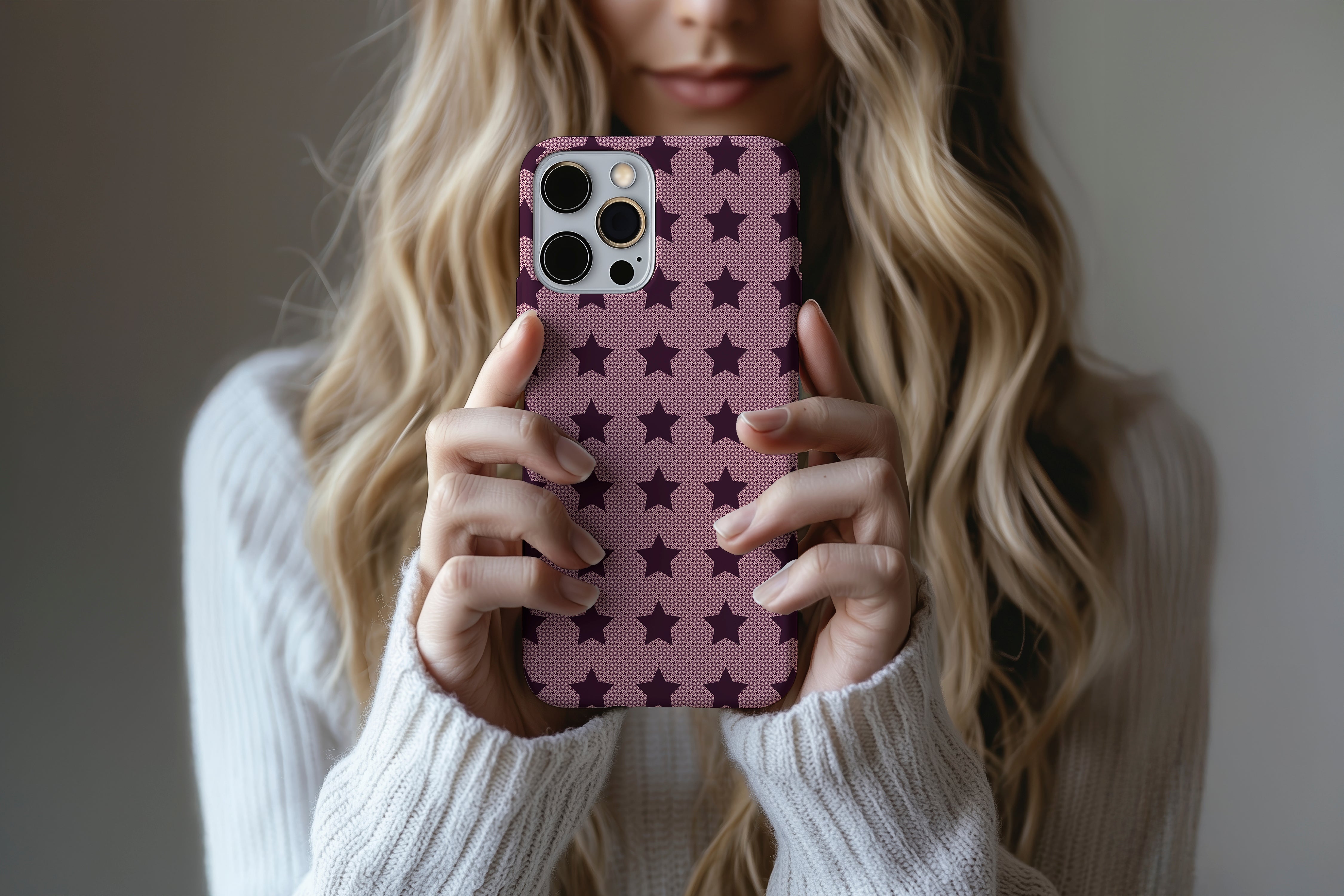 A cute girl holding a phone case featuring our Burgundy Stars design