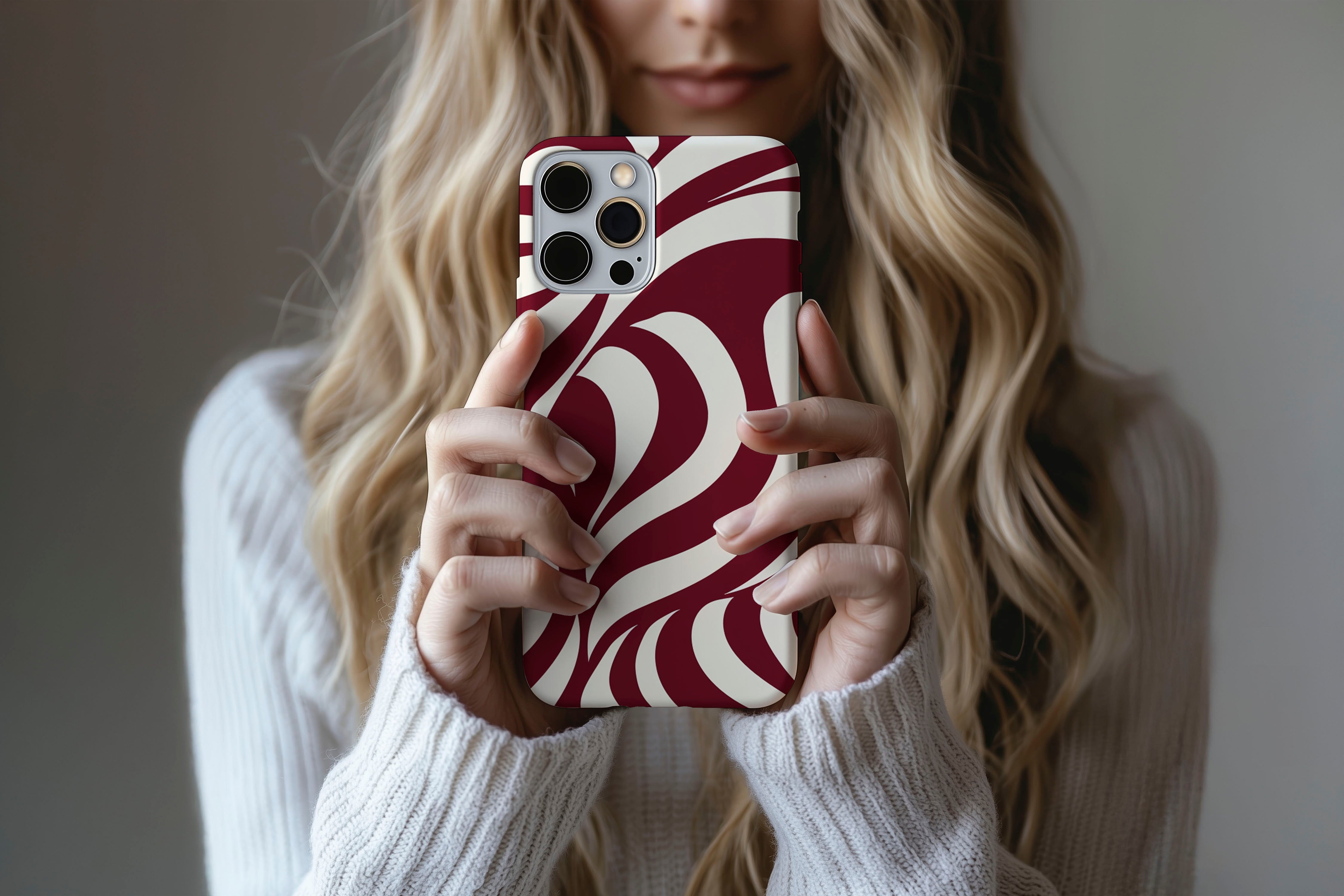 A cute girl holding a phone case featuring our Burgundy Twist design