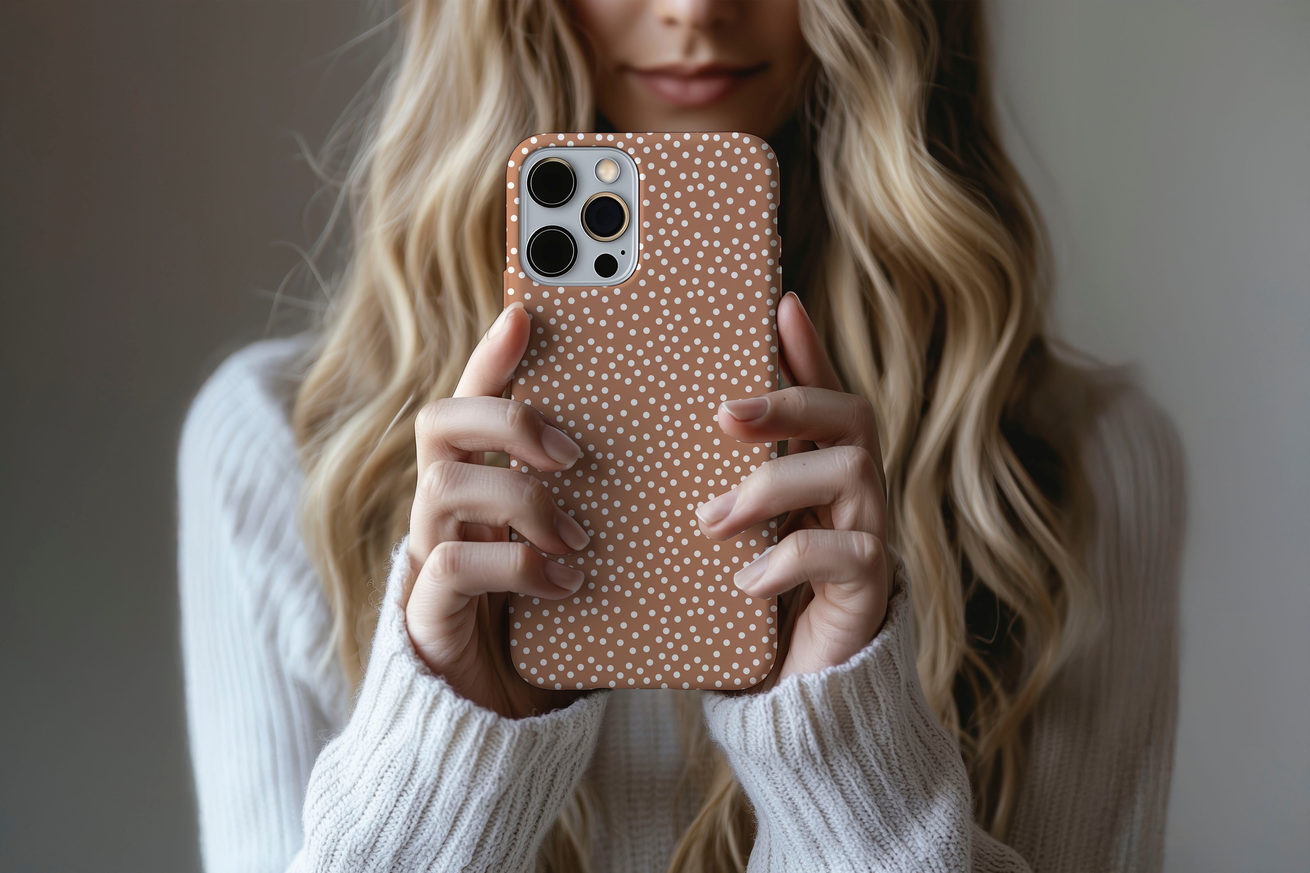 A cute girl holding a phone case featuring our Caramel Dot design