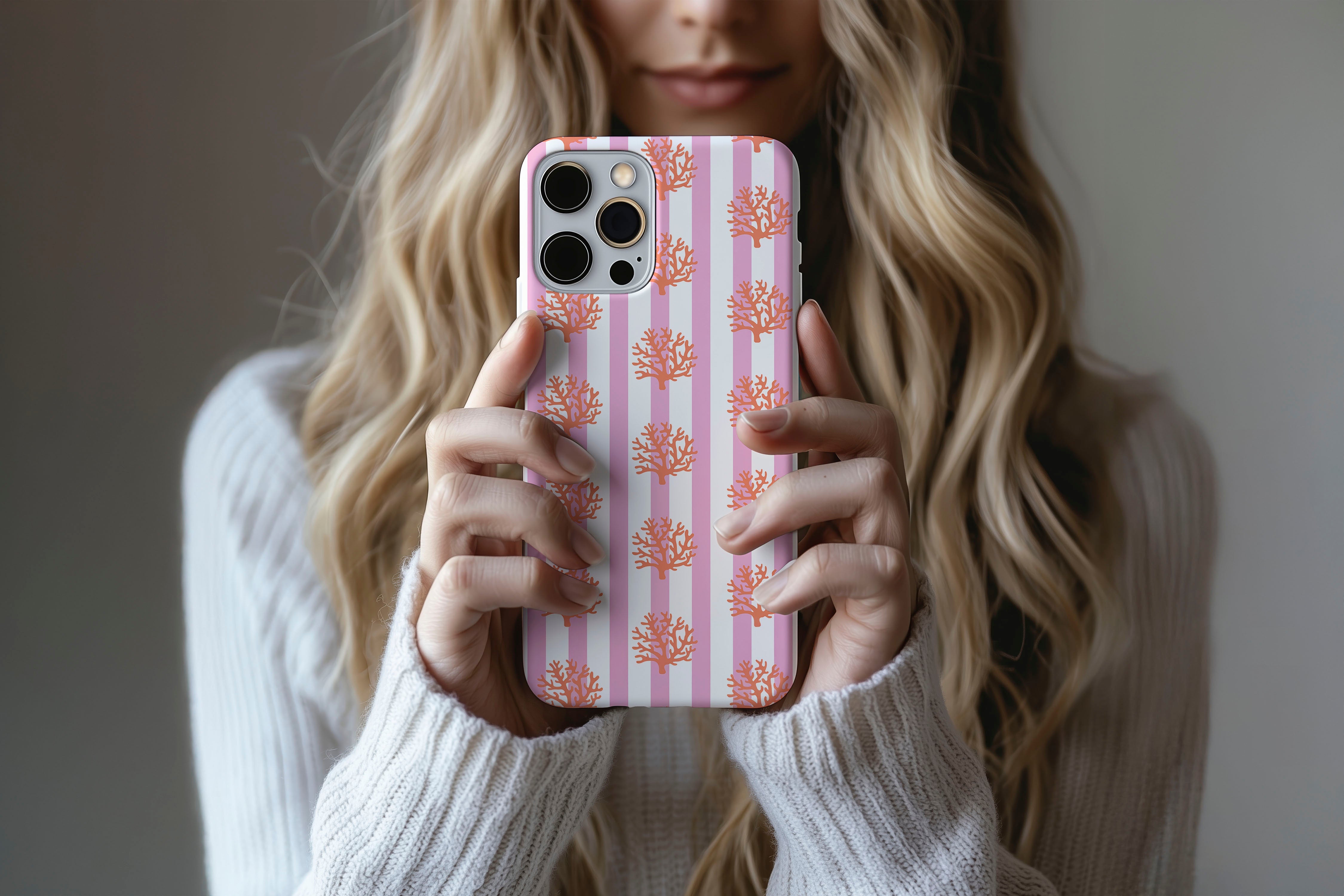 A cute girl holding a phone case featuring our Coral design