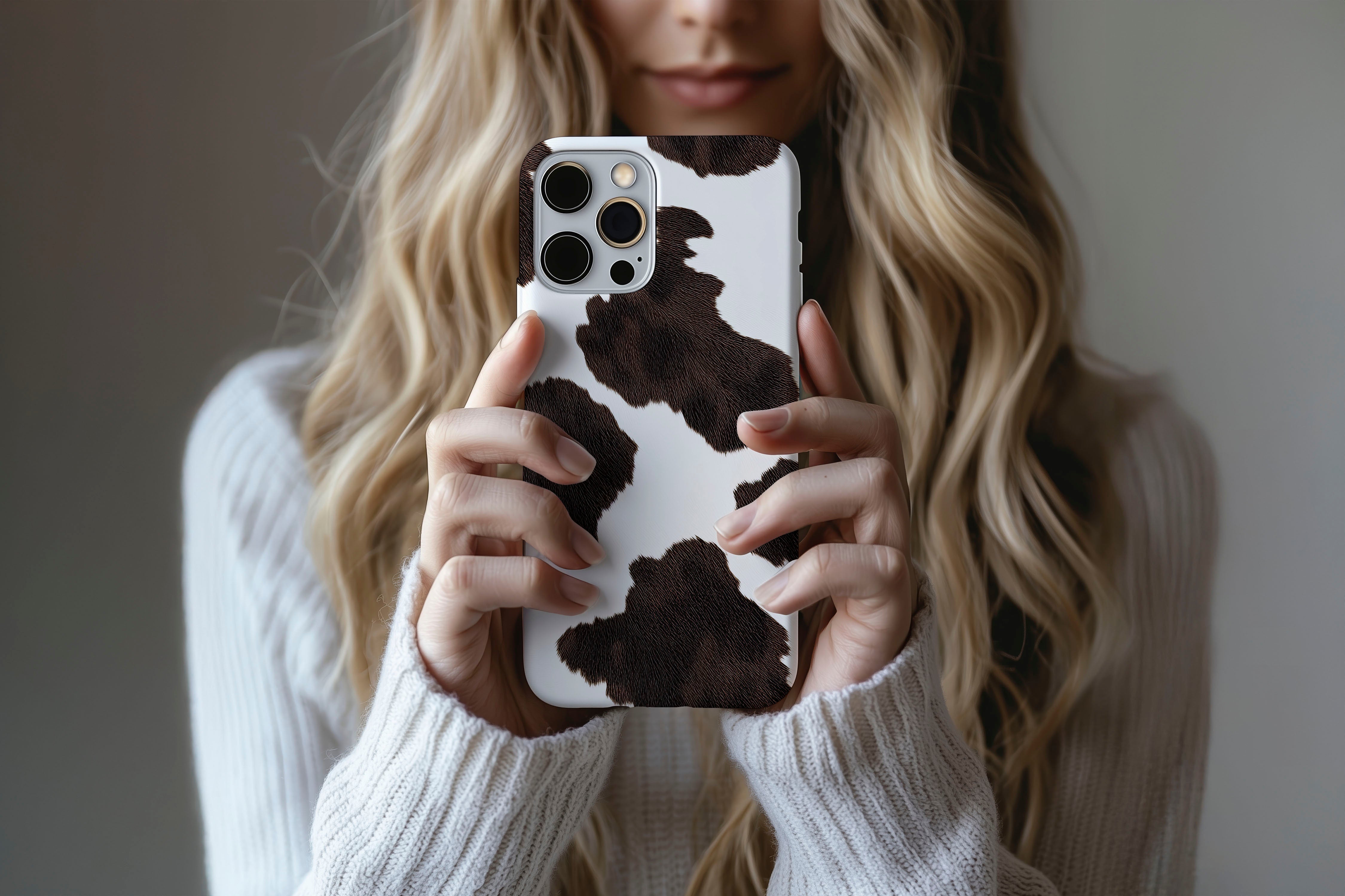 A cute girl holding a phone case featuring our Cow Hide design