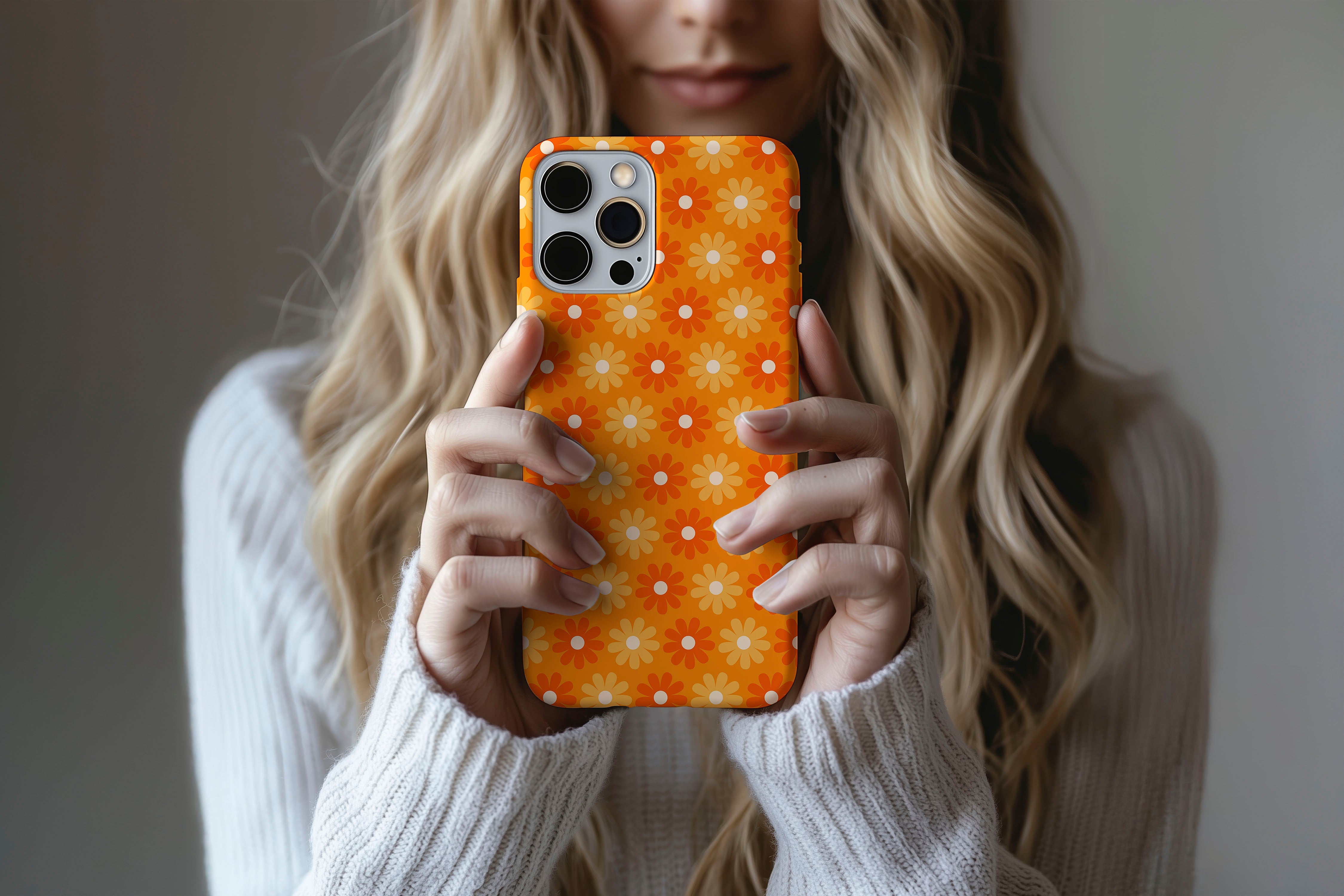 A cute girl holding a phone case featuring our Flaming Daisy design