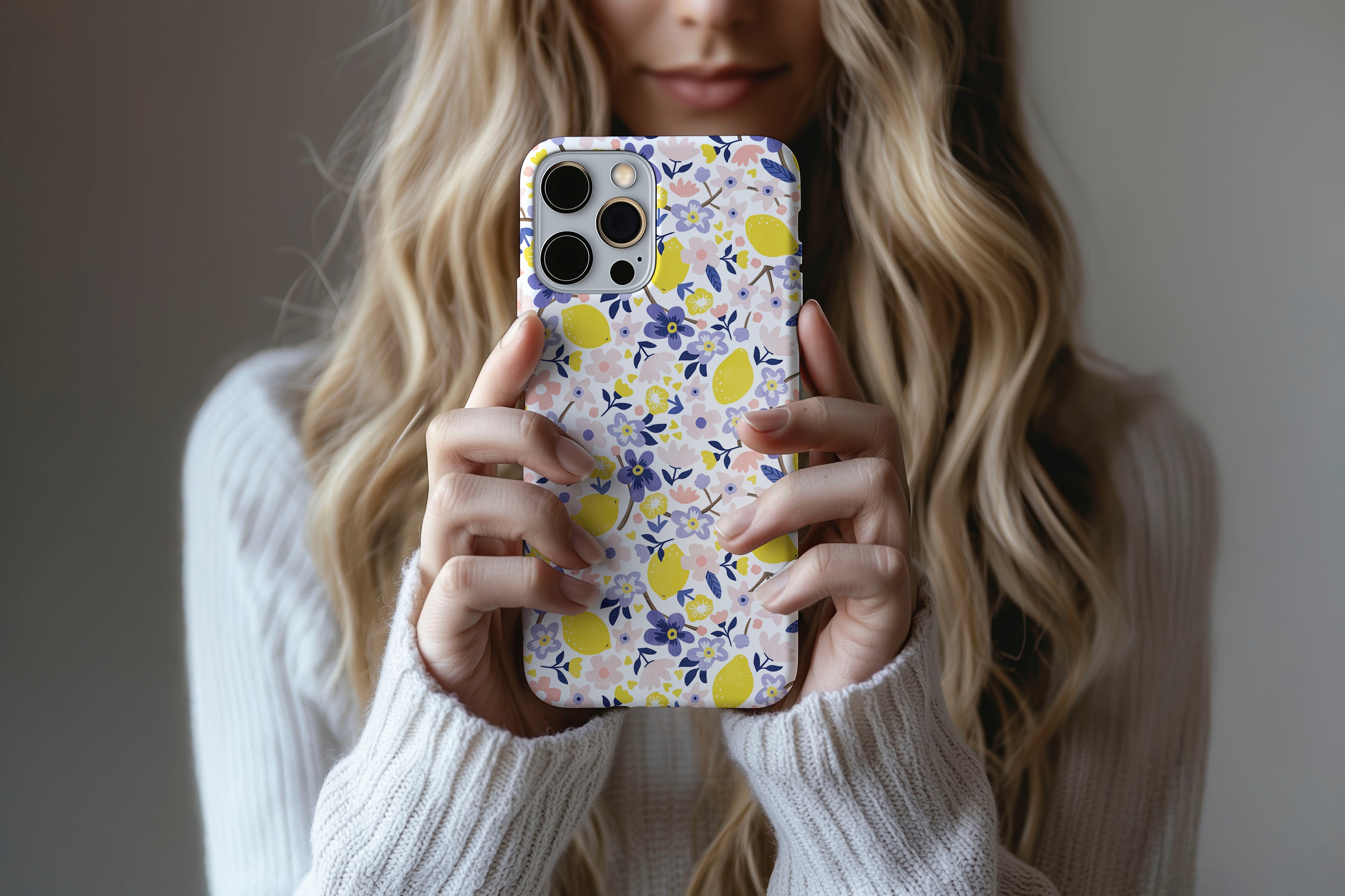 A cute girl holding a phone case featuring our Flora Lemon design