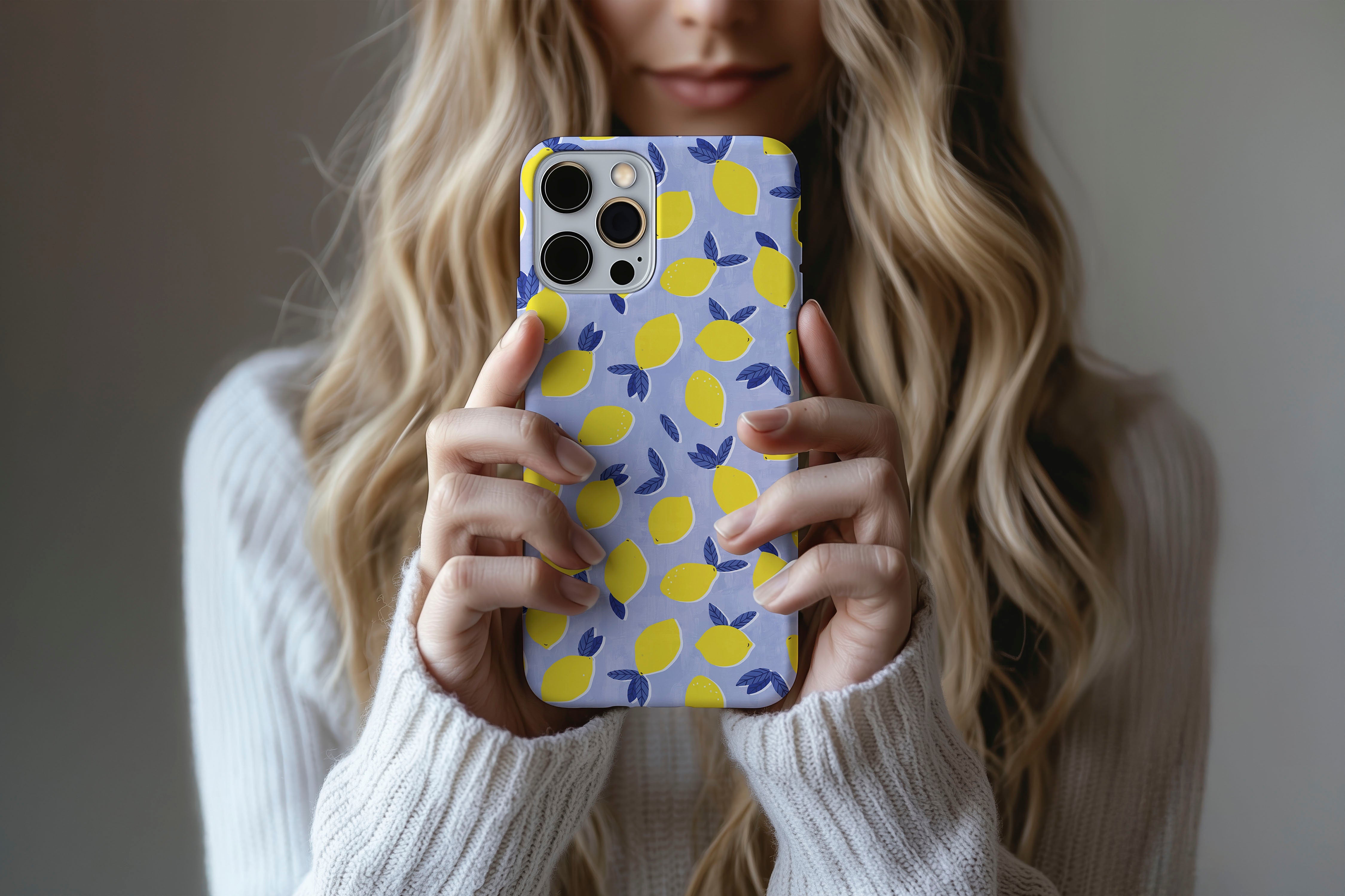 A cute girl holding a phone case featuring our Lemon Drop design
