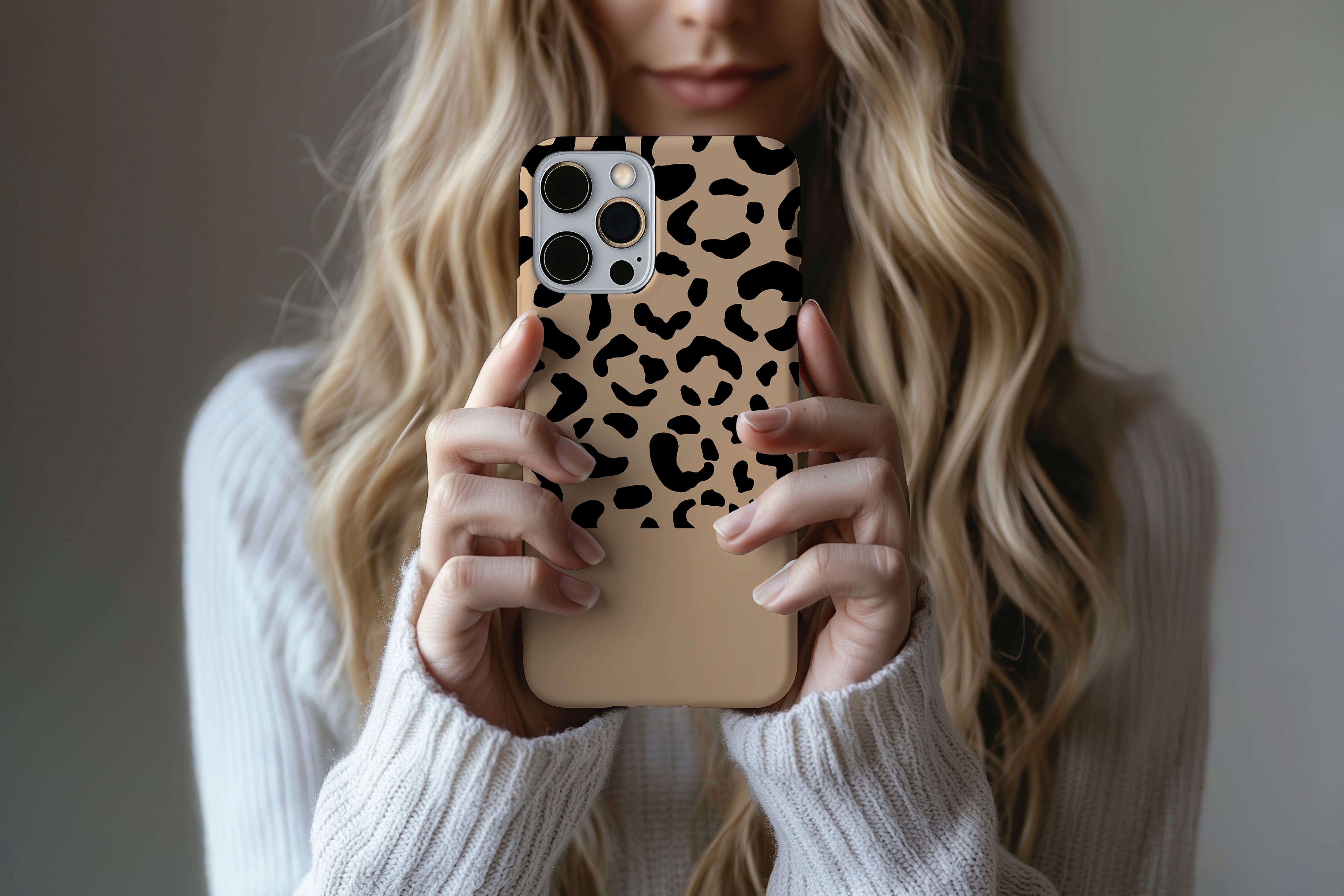 A cute girl holding a phone case featuring our Mocca Leopard design