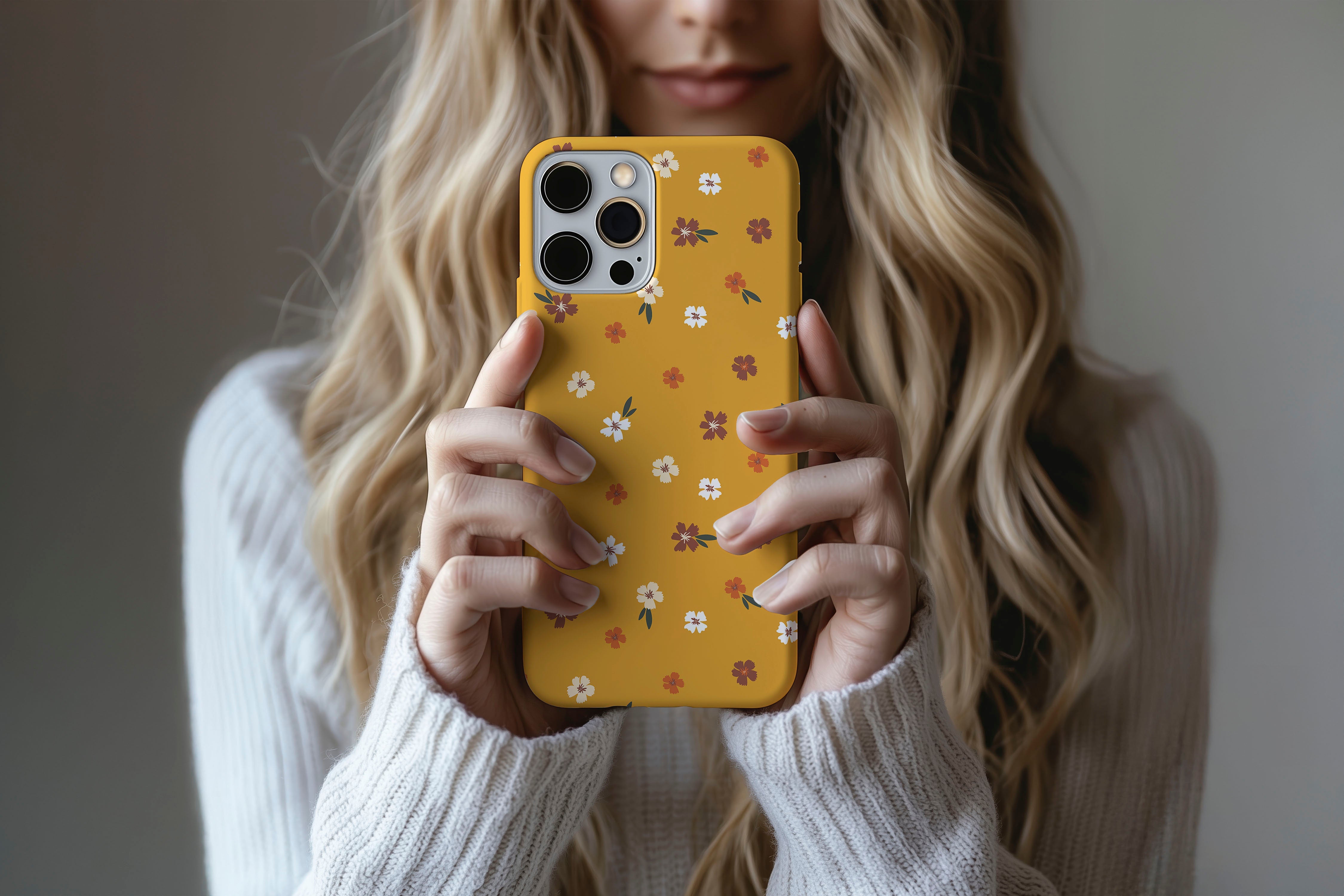A cute girl holding a phone case featuring our Mustard Floral design