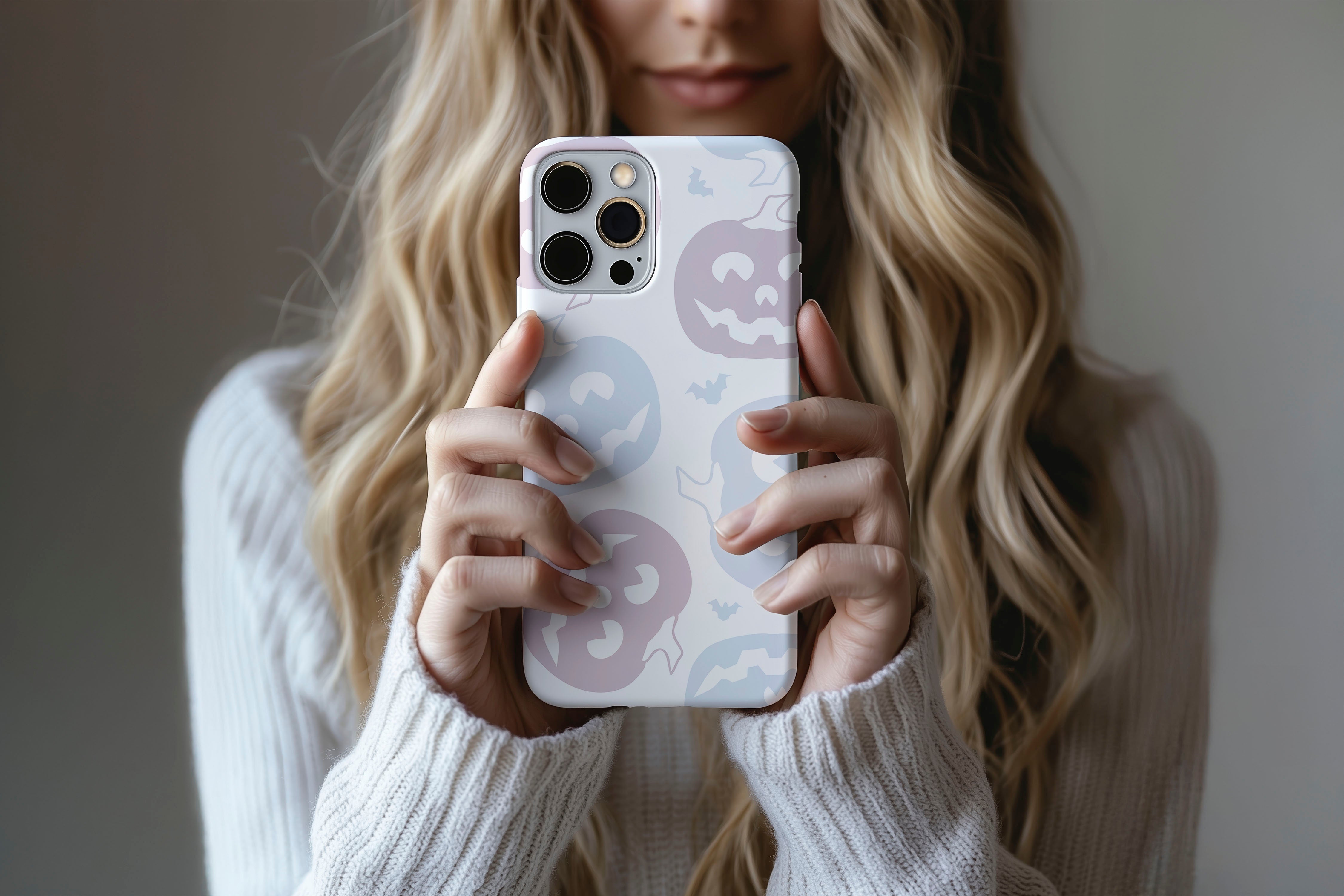 A cute girl holding a phone case featuring our Pastel Pumpkin design