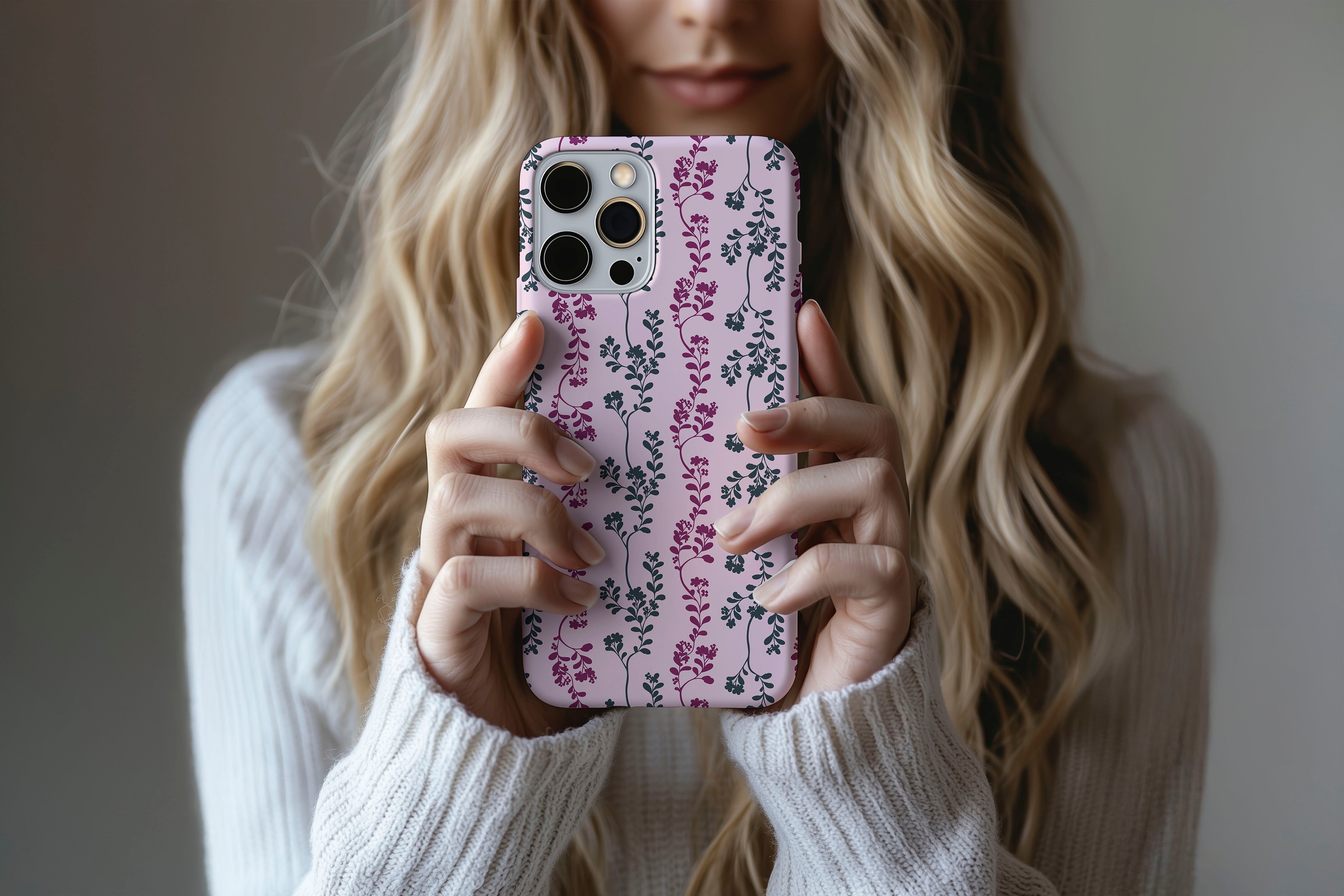 A cute girl holding a phone case featuring our Pretty Pink Leaf design