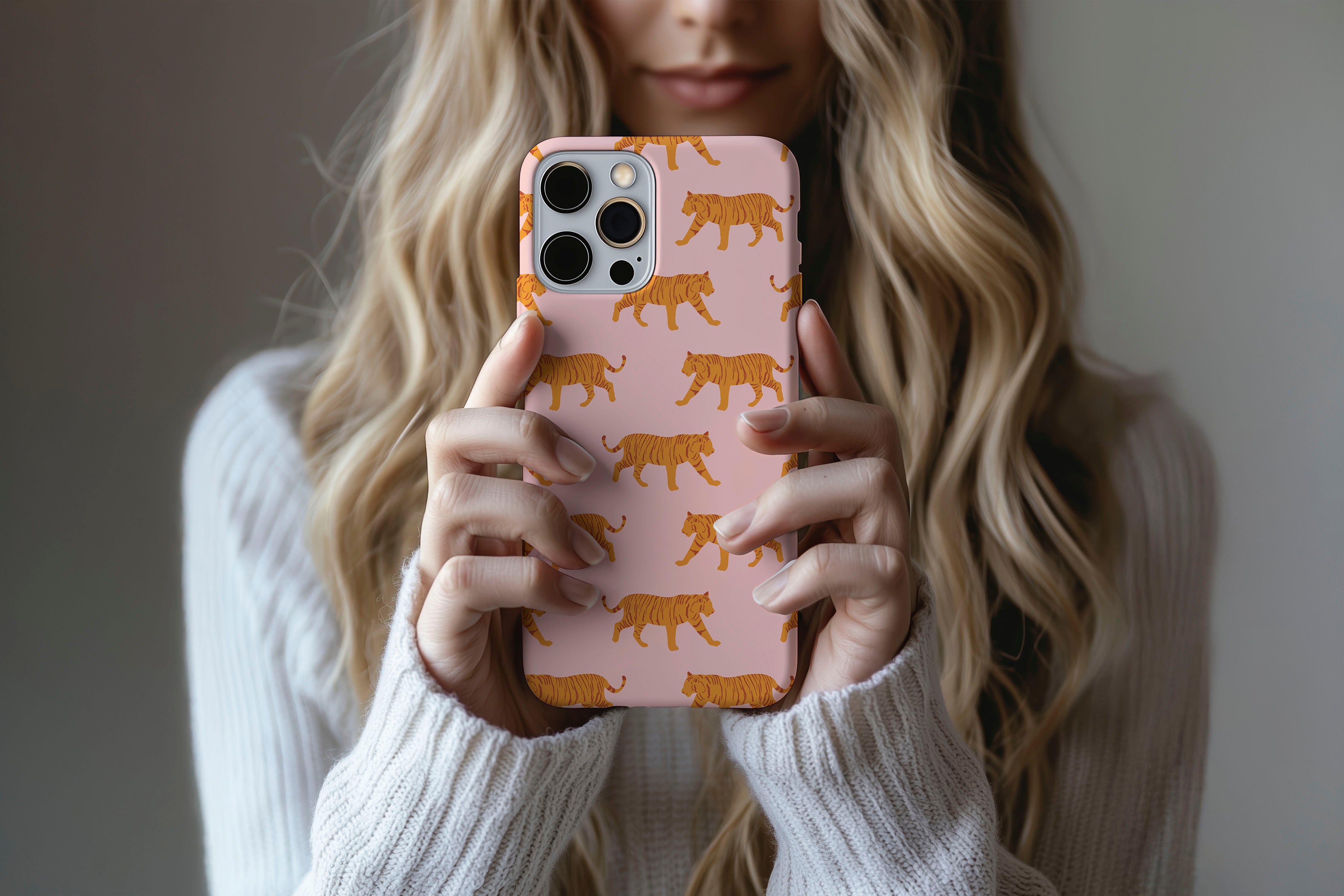 A cute girl holding a phone case featuring our Tigers design