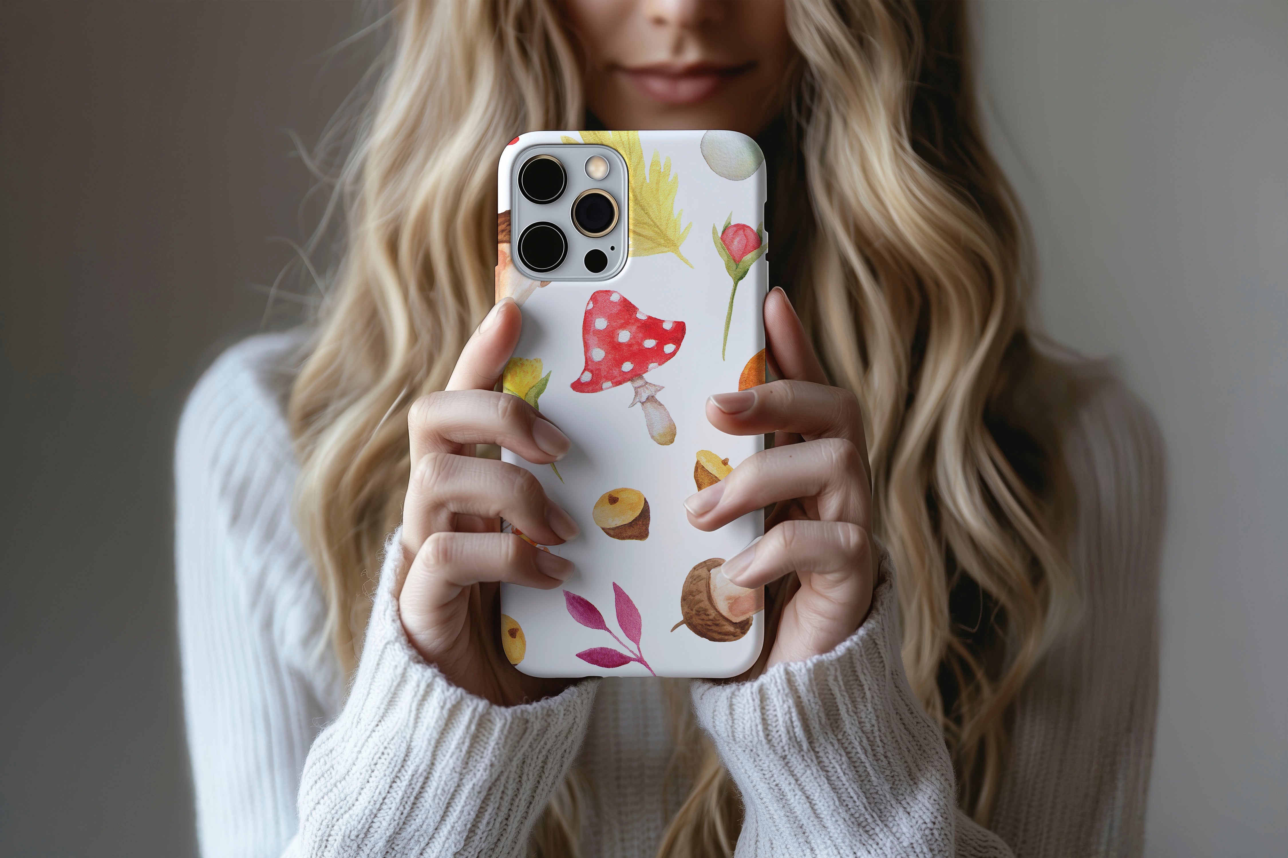 A cute girl holding a phone case featuring our Watercolour Autumn design