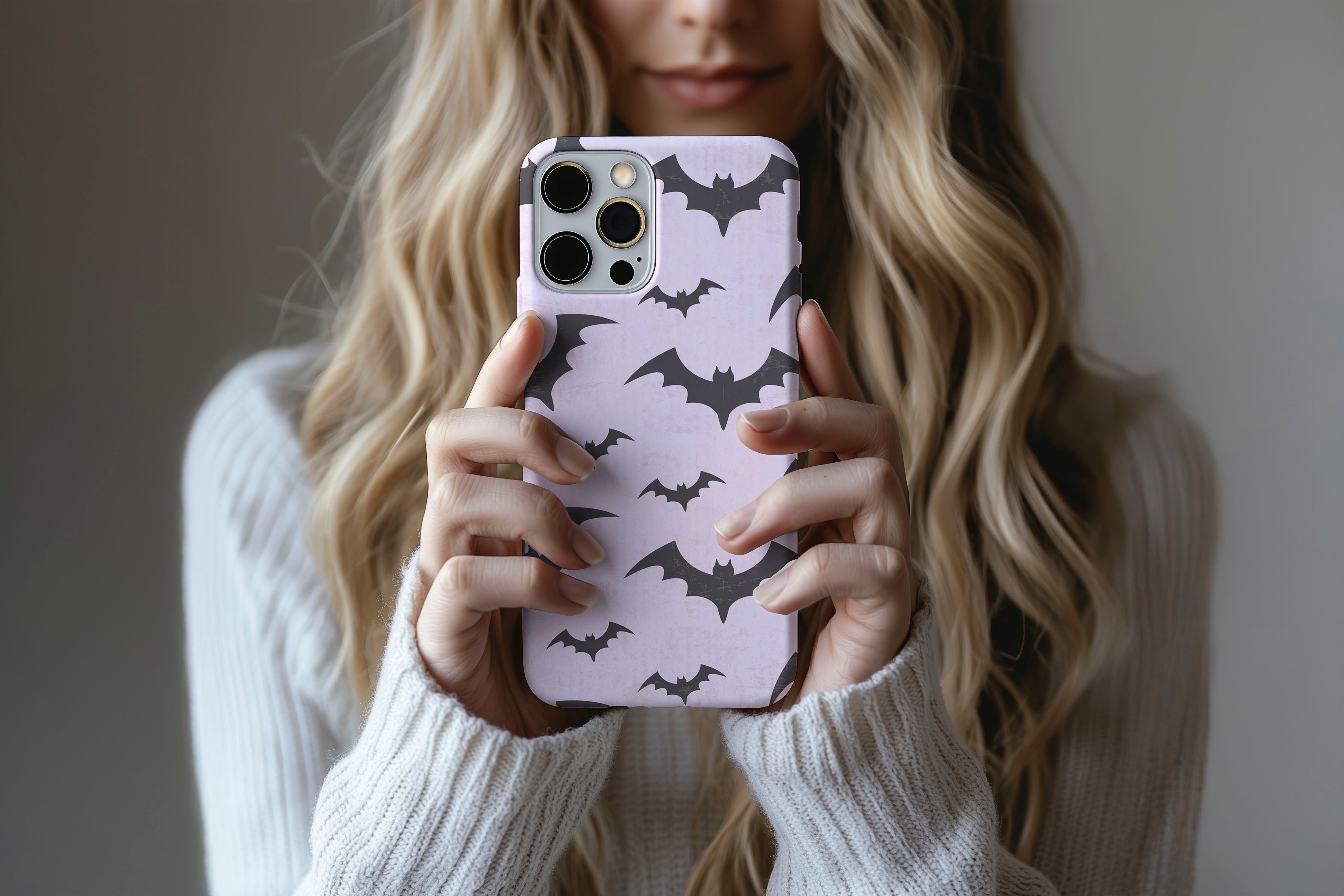 A cute girl holding a phone case featuring our Watercolour Bats design