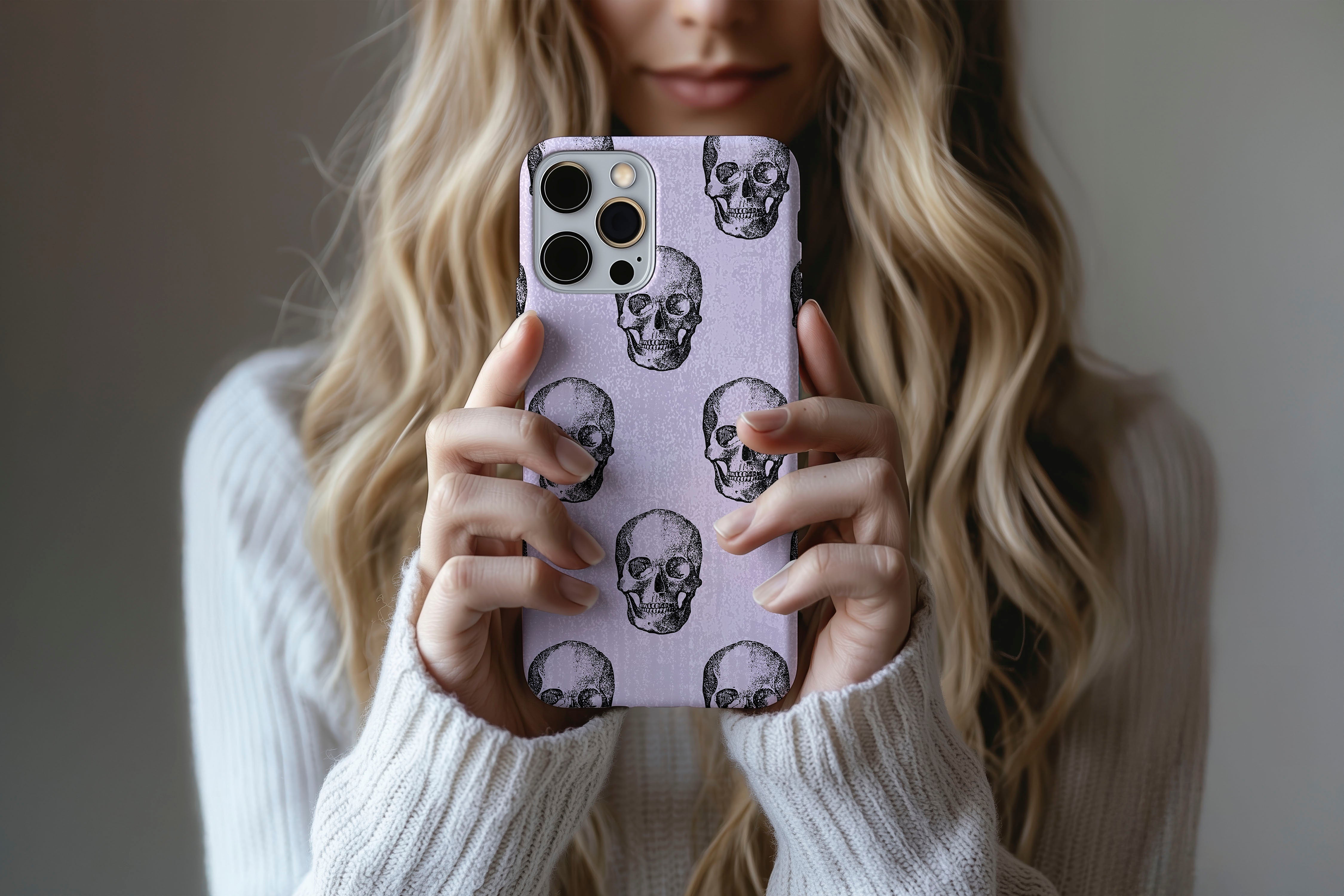 A cute girl holding a phone case featuring our Watercolour Skull design