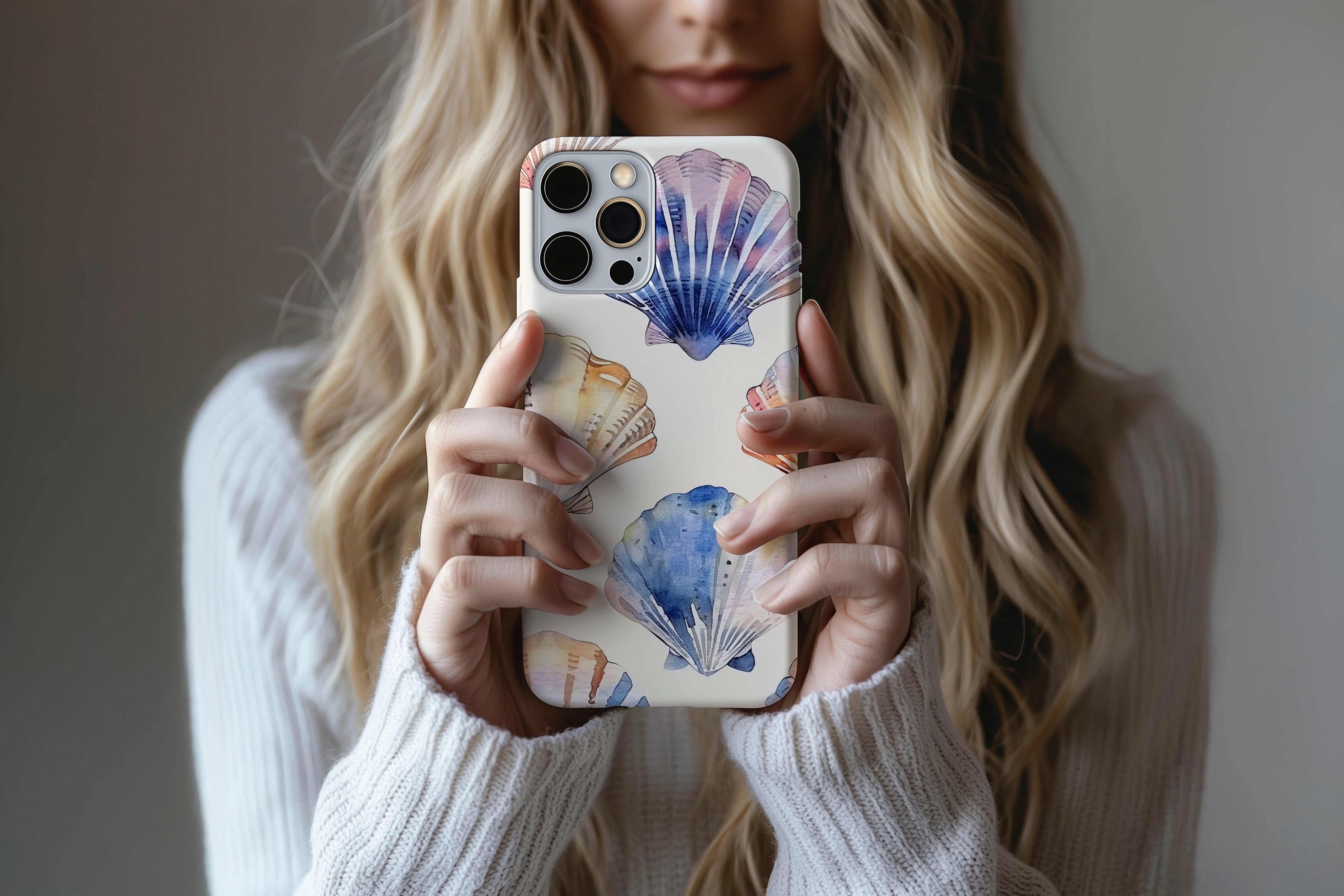 A cute girl holding a phone case featuring our Shells design