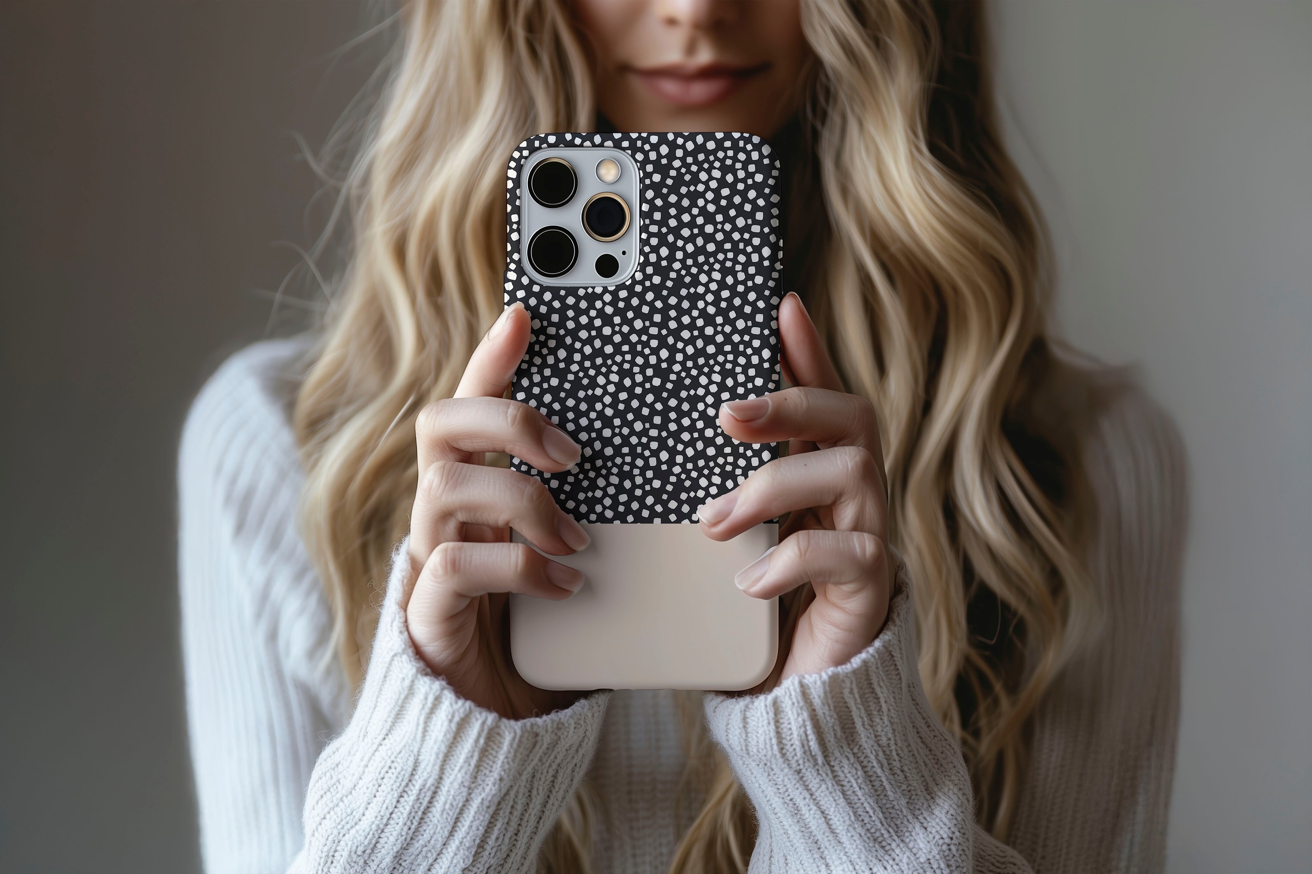 A cute girl holding a phone case featuring our Black Spots design