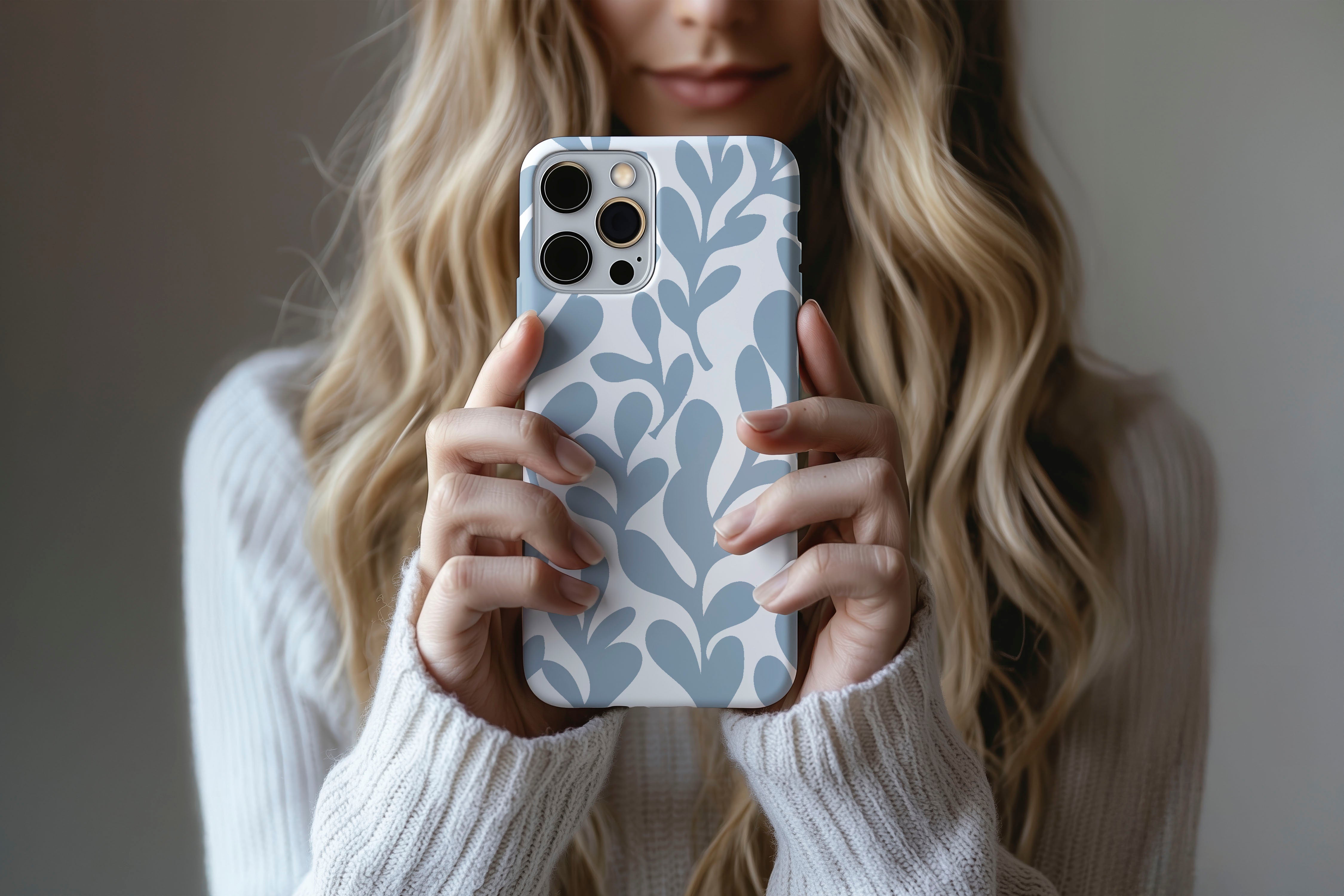 A cute girl holding a phone case featuring our Ice Blue Leaf design