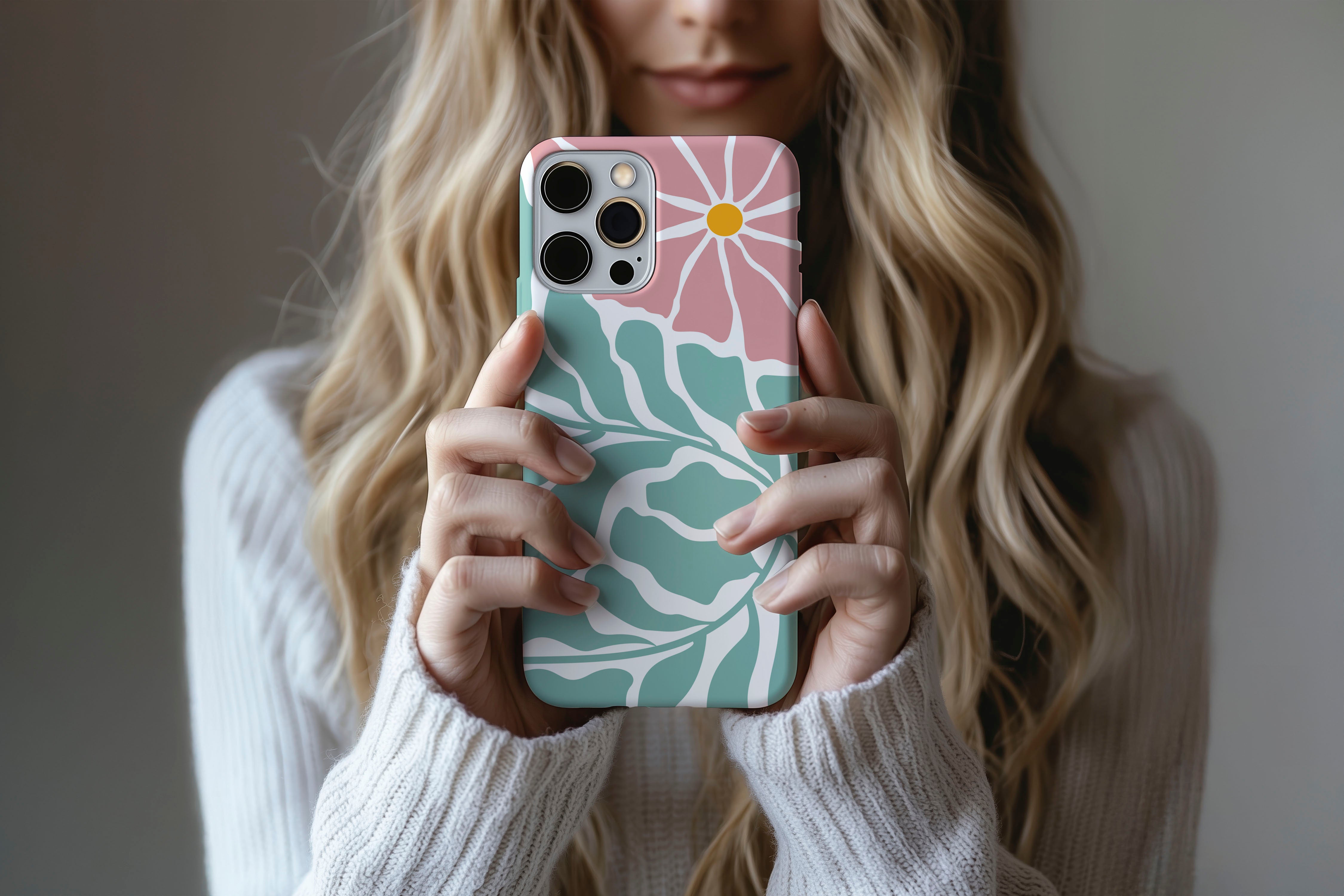 A cute girl holding a phone case featuring our Pink Cosmos design