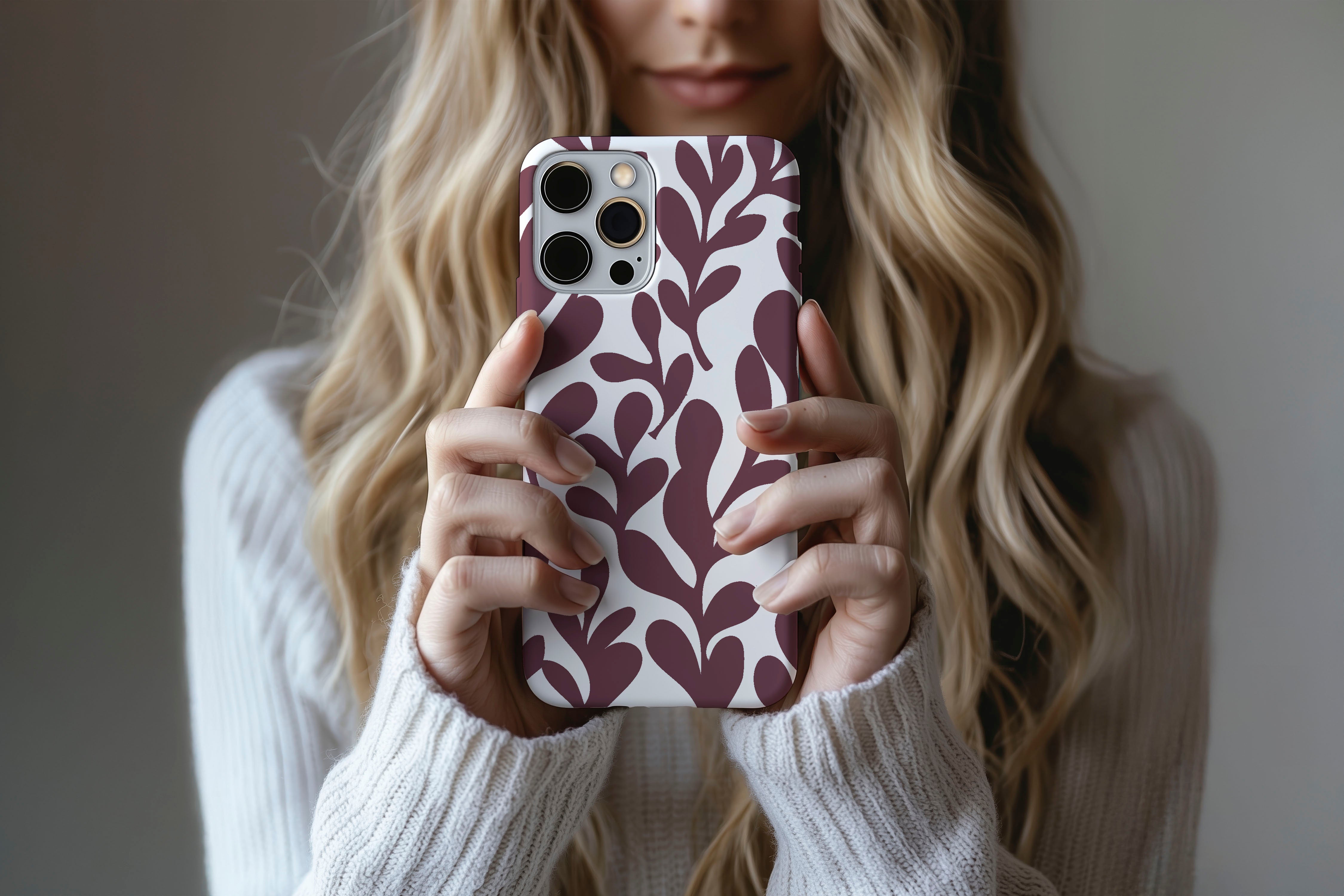 A cute girl holding a phone case featuring our Port Leaf design